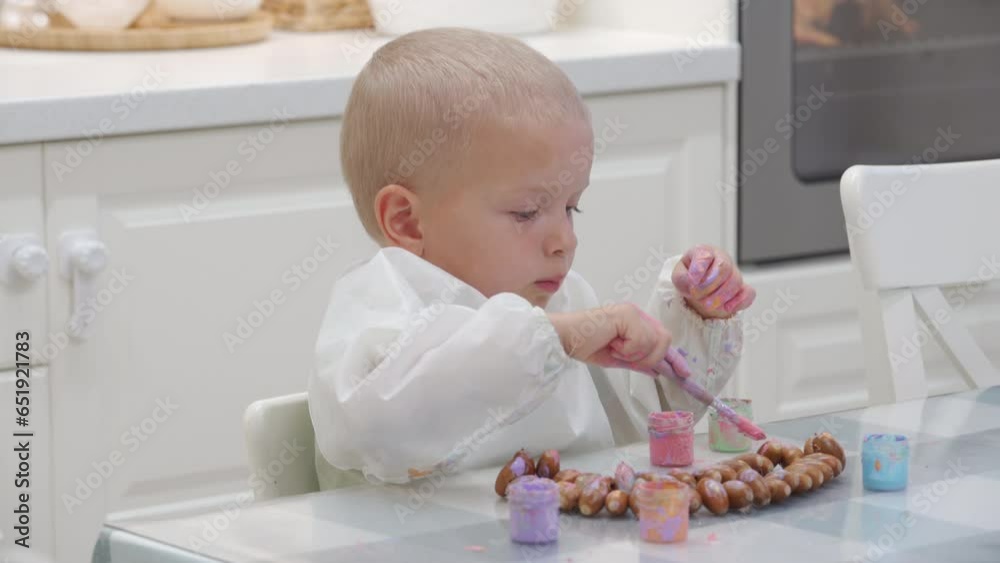 toddler child painting a necklace made of acorns with finger paints toddler child painting a necklace made of acorns with finger paints