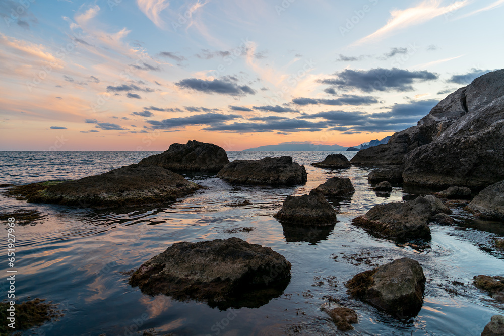 Sudak, Crimea. Bright contrasting sky after sunset. Rocks in the black sea