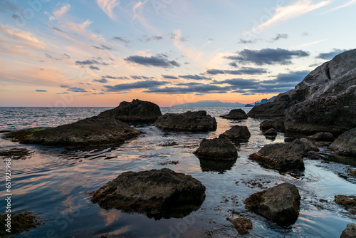 Sudak, Crimea. Bright contrasting sky after sunset. Rocks in the black sea