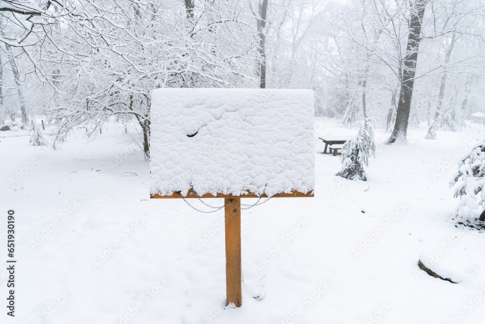 Fototapeta premium Wooden sign board in the snowy park