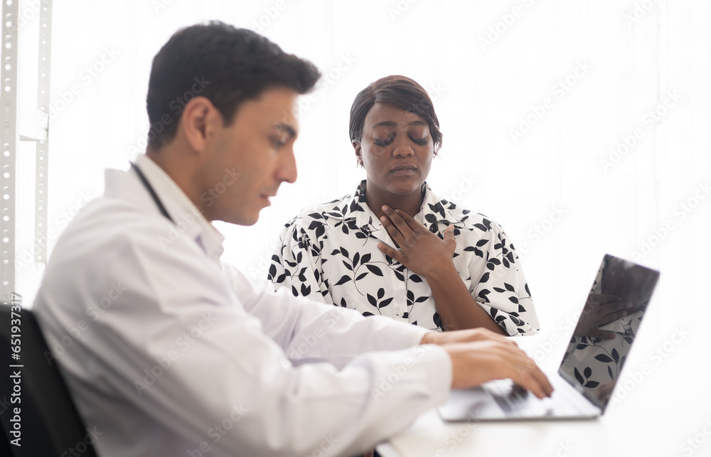 Hispanic physician check-up African American patient with stethoscope at the hospital. Healthcare medical diagnosis and examining on the laptop. Hispanic physician check-up African American patient with stethoscope at the hospital. Healthcare medical diagnosis and examining on the laptop.