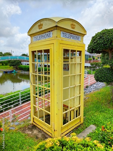 old yellow phone booth in the park
