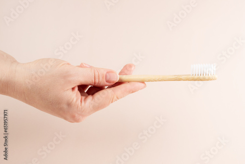 Eco toothbrushes in hand, wooden dental brushes for natural oral care