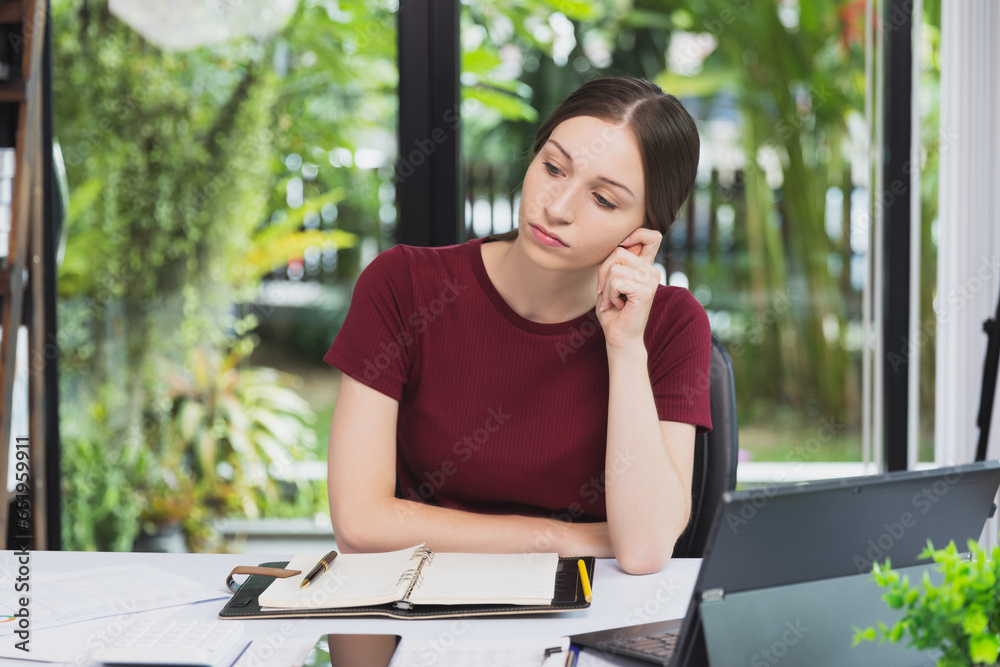 A businesswoman sits at her desk contemplating problems and questions from project work. Young woman holding a pen and thinking about work plan. Woman working on a laptop at a cafe. A businesswoman sits at her desk contemplating problems and questions from project work. Young woman holding a pen and thinking about work plan. Woman working on a laptop at a cafe.