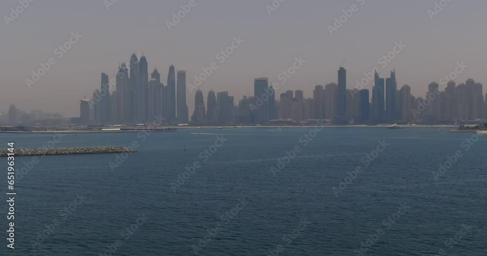 The drone flies over the waves of the sea towards the city on the shore. Dubai, United Arab Emirates The drone flies over the waves of the sea towards the city on the shore. Dubai, United Arab Emirates