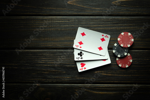 Gambling poker game with three of a kind winning combination. Cards with chips on a black table in a poker club. Free space for advertising.