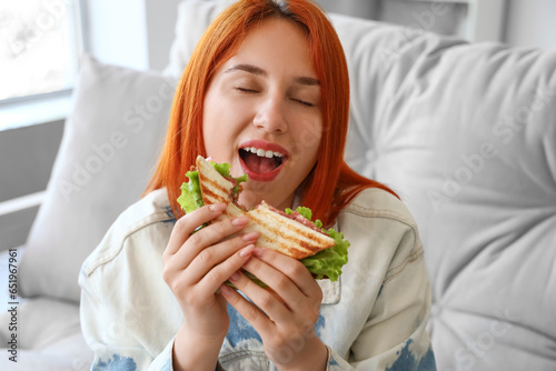 Young redhead woman eating ...