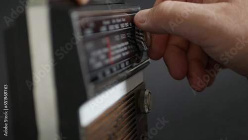 Blurred Shooting with One Person Searching a News Radio Station or a Music Radio Station Using an Old Radio. Man Searching a Broadcasting Frequency by Rotating a Radio Button.