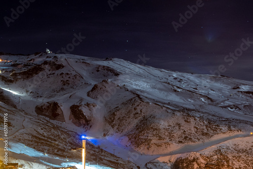 night view of Veleta peak in Sierra Nevada, in Granada (Spain), with the ski resort, night lights and a large radio telescope photo