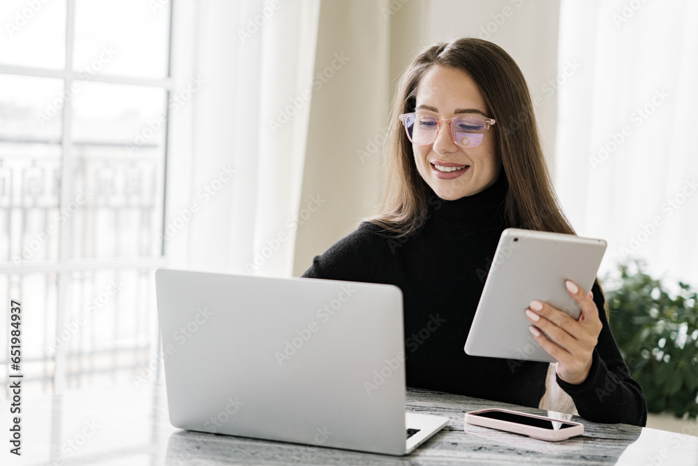 Female programmer is a young specialist application tester. The SMM manager works remotely consulting online for the client. Freelancer in office clothes in a coworking space. Female programmer is a young specialist application tester. The SMM manager works remotely consulting online for the client. Freelancer in office clothes in a coworking space.