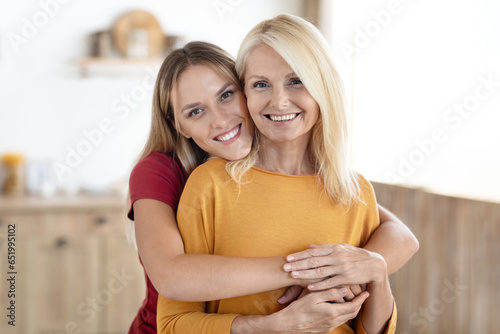 Loving millennial woman daughter hugging her senior mother