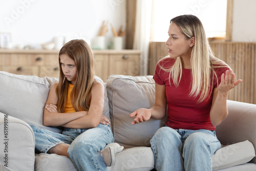Woman mother scolding her stubborn daughter at home photo