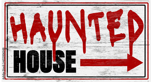 Aged and worn haunted house sign on wood grain.
