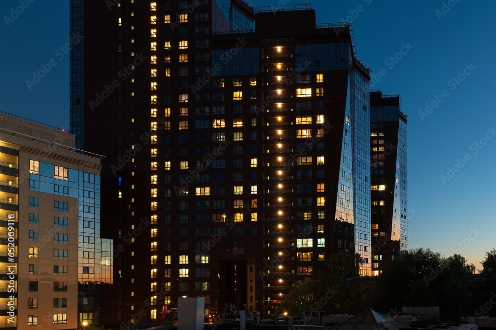 Night architecture. Skyscrapers with glass facade. Modern house building in the sunset light Night architecture. Skyscrapers with glass facade. Modern house building in the sunset light