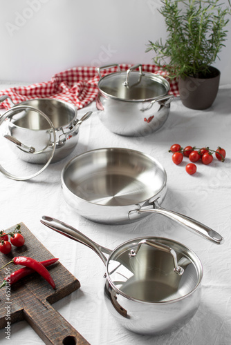 Set of stainless pots with lids and vegetables