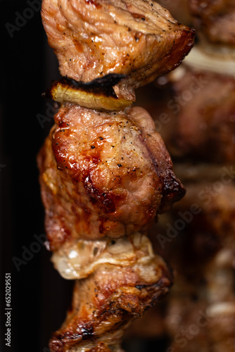 Cooking pork meat in an electric kebab maker on vertical skewers