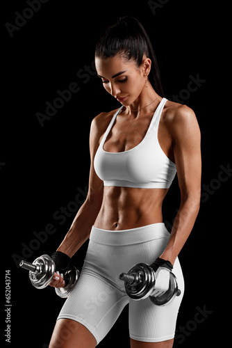 Fitness woman showing abs and flat belly on black background. Beautiful athletic girl, shaped abdominal
