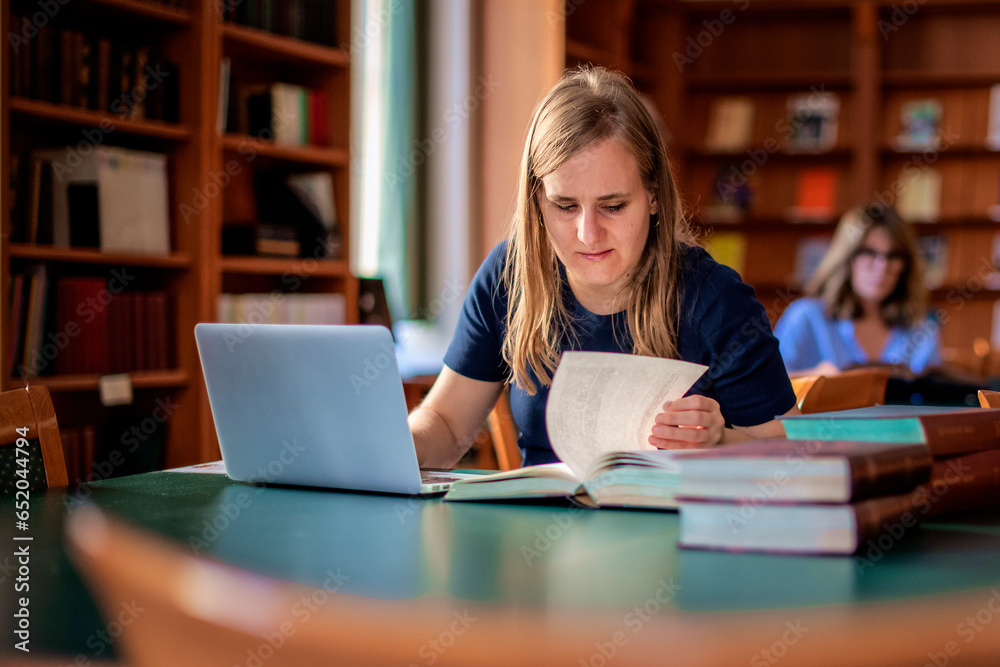 A visually impaired young woman sitting and studying in the university library A visually impaired young woman sitting and studying in the university library