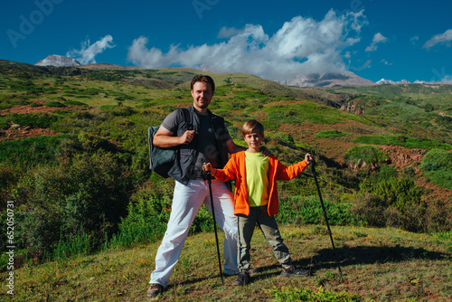 Happy father and son hikers standing on the mountain