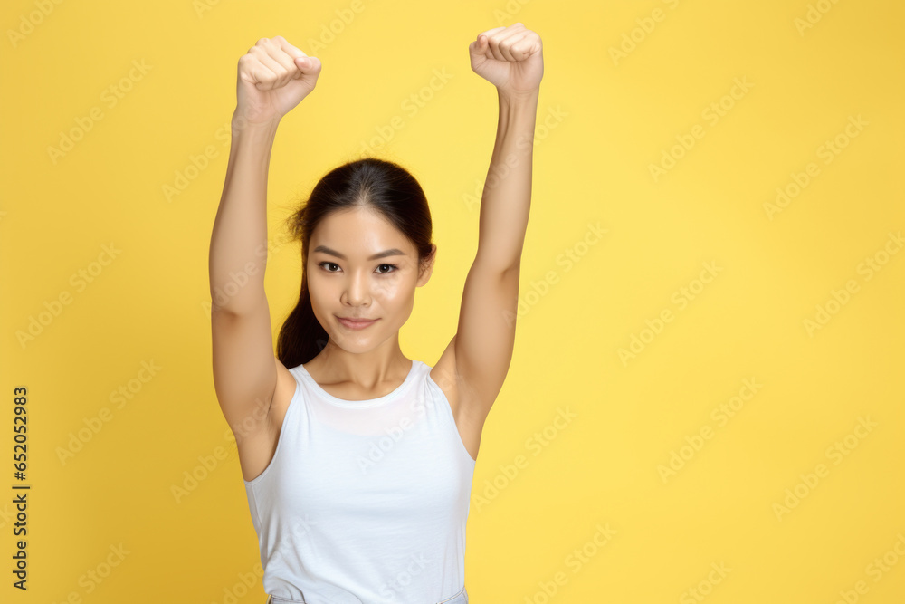 Woman in white tank top is raising her arms. This versatile image can be used to portray joy, celebration, victory, or exercise.