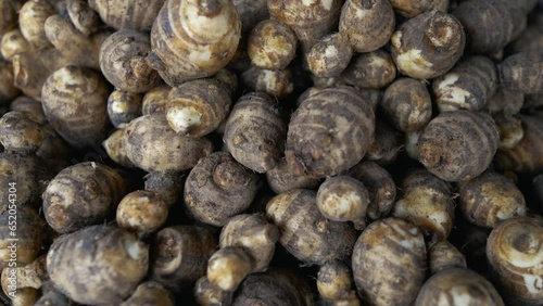 Organic fresh raw taro roots at market. Taro, also known as dasheen, eddo, kalo, or colocasia, is a starchy root vegetable that is popular in many cuisines around the world.