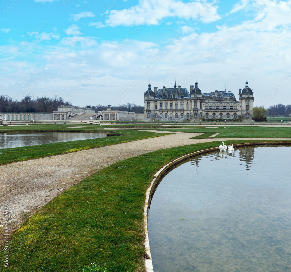 The Chateau de Chantilly (France) and swans in pond. The Grand Chateau rebuilt in the 1870 s (architect Honore Daumet).