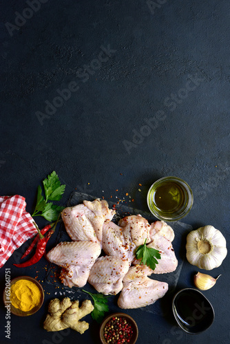 Raw chicken wings with ingredients for making. Top view with copy space.