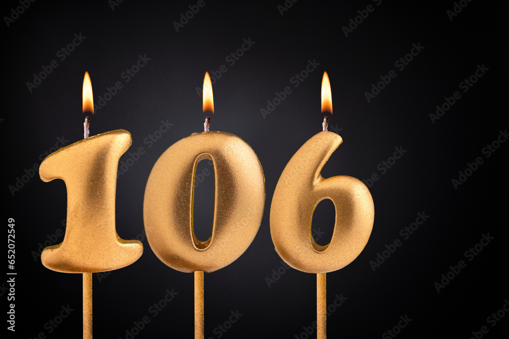 Golden candle 106 with flame - Birthday card on dark luxury background Golden candle 106 with flame - Birthday card on dark luxury background
