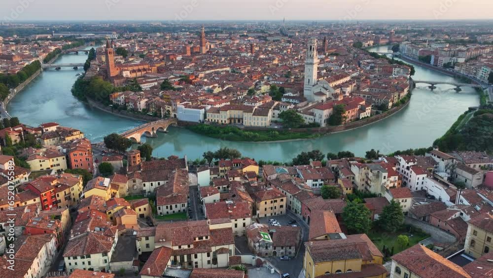 Establishing Aerial View Shot of Verona historical city centre, Ponte Pietra bridge across Adige river, Verona Cathedral, Duomo di Verona, red tiled roofs, Veneto Region, Italy, track in