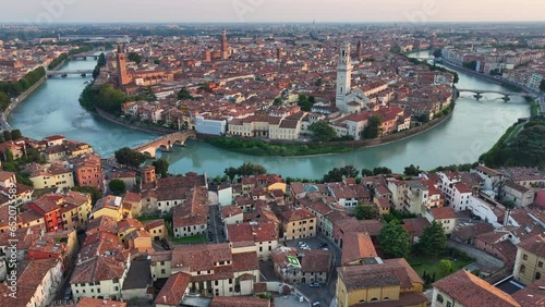 Establishing Aerial View Shot of Verona historical city centre, Ponte Pietra bridge across Adige river, Verona Cathedral, Duomo di Verona, red tiled roofs, Veneto Region, Italy, track in