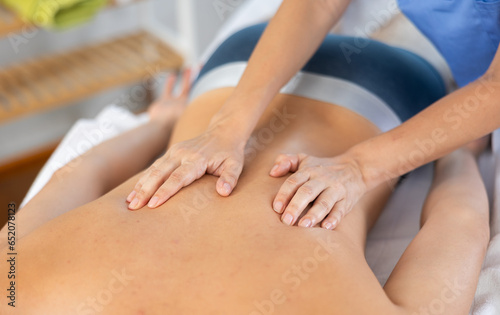 Man receiving massage relax treatment close-up. Masseur hands doing back massage in spa center