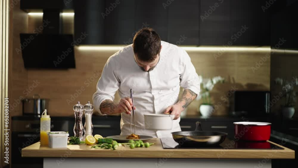 Young bearded chef putting a red prawns on the top of pasta into the plate. Slow-motion shot Young bearded chef putting a red prawns on the top of pasta into the plate. Slow-motion shot