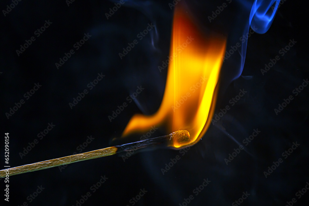 Fire and smoke. Burning and smoking match on a black background. Heat and light from fire flame Fire and smoke. Burning and smoking match on a black background. Heat and light from fire flame