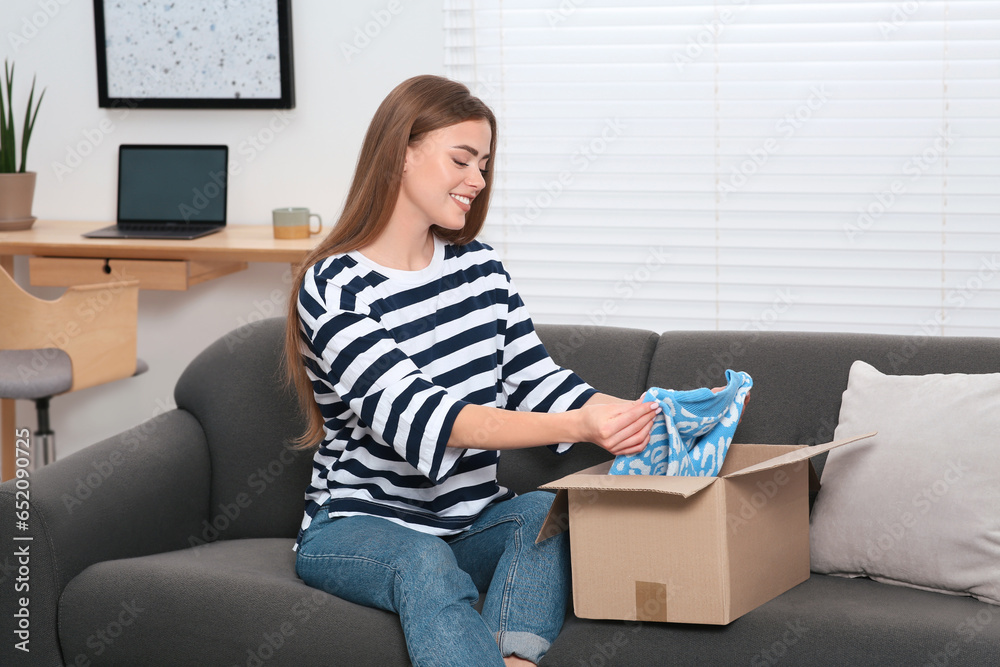 Happy woman unpacking parcel at home. Online store Happy woman unpacking parcel at home. Online store