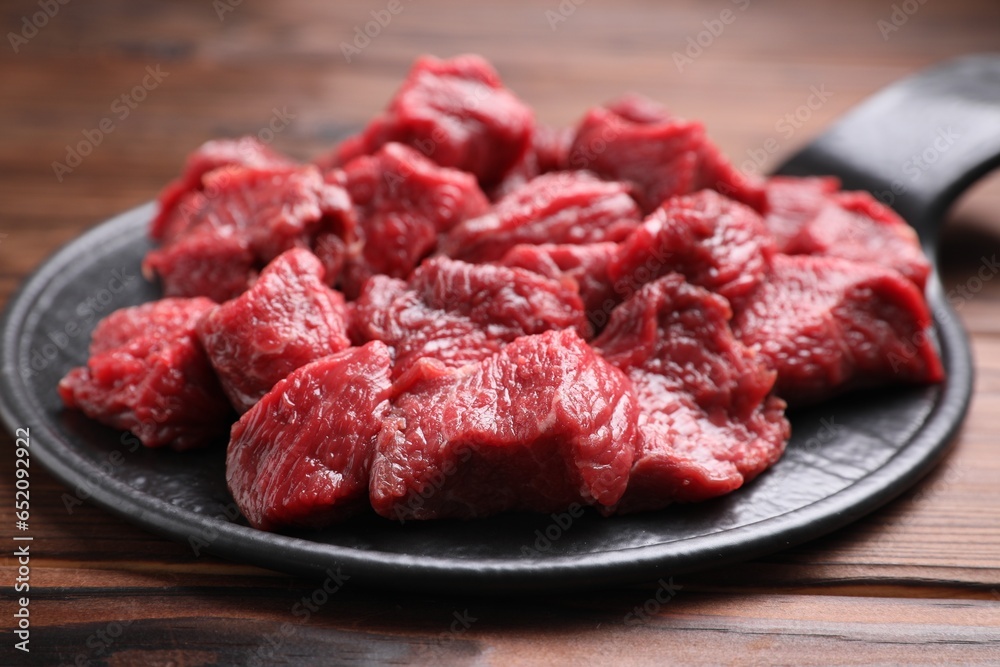 Pieces of raw beef meat on wooden table, closeup Pieces of raw beef meat on wooden table, closeup