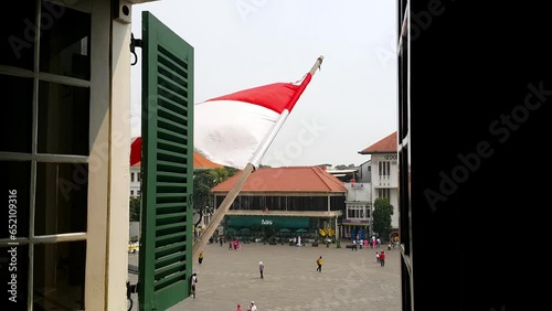 Jakarta, Indonesia - July 22, 2023: The Indonesian red and white flag flutters on top of the old Dutch heritage building. View from the window.