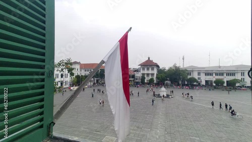 Jakarta, Indonesia - July 22, 2023: The Indonesian red and white flag flutters on top of the old Dutch heritage building. View from the window.