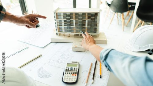 Photos Two engineer discussion and brainstorming about condominium model of constructio