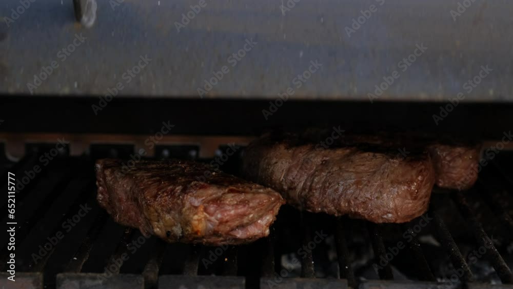 Opening the lid of grill to check beef steaks on grid Stock ビデオ Adobe