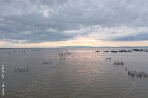 Aerial view of fishing trap net in canel with fisherman urban city village town houses  lake or river. Nature landscape fisheries and fishing tools at Pak Pha  Songkhla  Thailand. Aquaculture farming