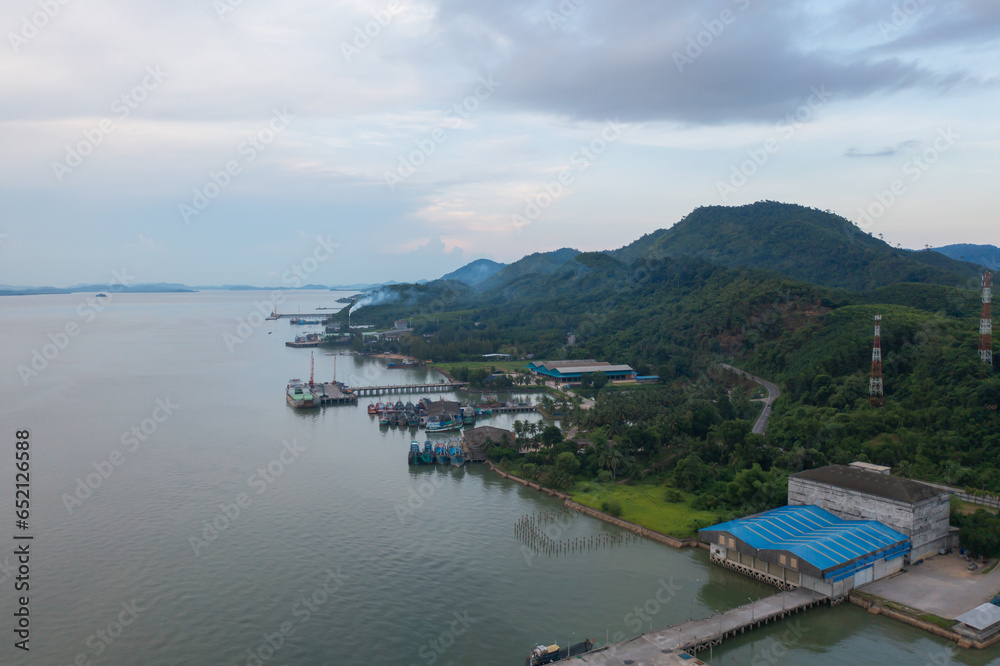 Fototapeta premium Aerial view of fishing trap net in canel with fisherman urban city village town houses, lake or river. Nature landscape fisheries and fishing tools at Pak Pha, Songkhla, Thailand. Aquaculture farming