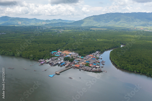Aerial view of fishing trap net in canel with fisherman urban city village town houses, lake or river. Nature landscape fisheries and fishing tools at Pak Pha, Songkhla, Thailand. Aquaculture farming