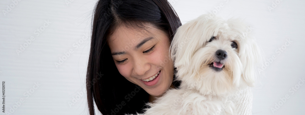 Young asian woman carrying with fluffy dog shih tzu with love in living room at home, friends pet with companion, woman playful and hug with animal for relax, female and friendly of puppy. Young asian woman carrying with fluffy dog shih tzu with love in living room at home, friends pet with companion, woman playful and hug with animal for relax, female and friendly of puppy.