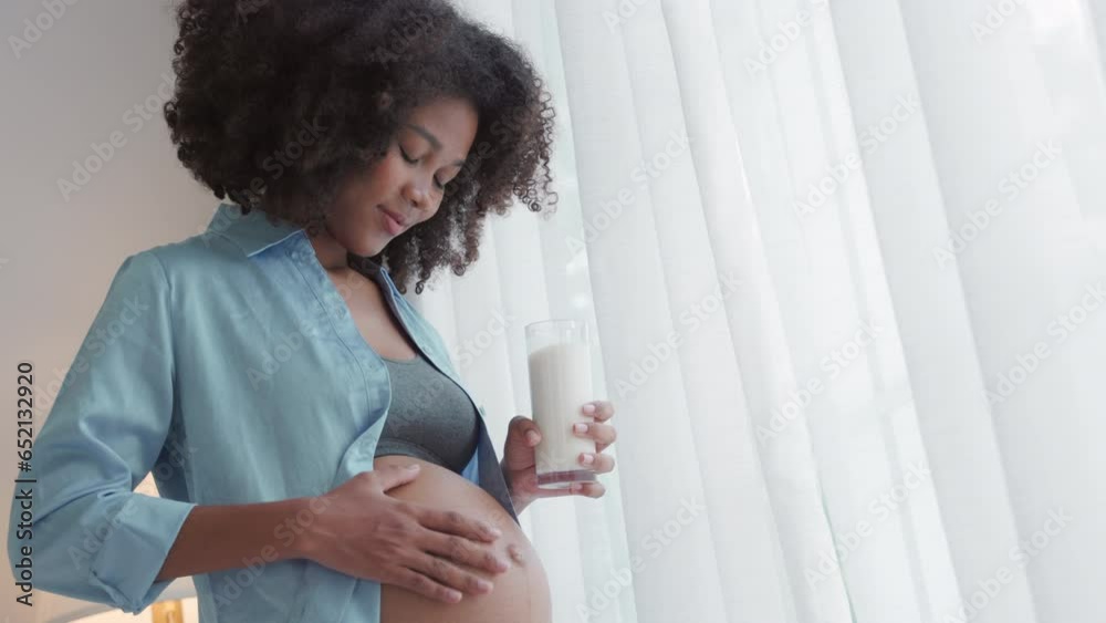 Happy Pregnant African Woman Drinking Milk by window in Slow Motion Happy Pregnant African Woman Drinking Milk by window in Slow Motion