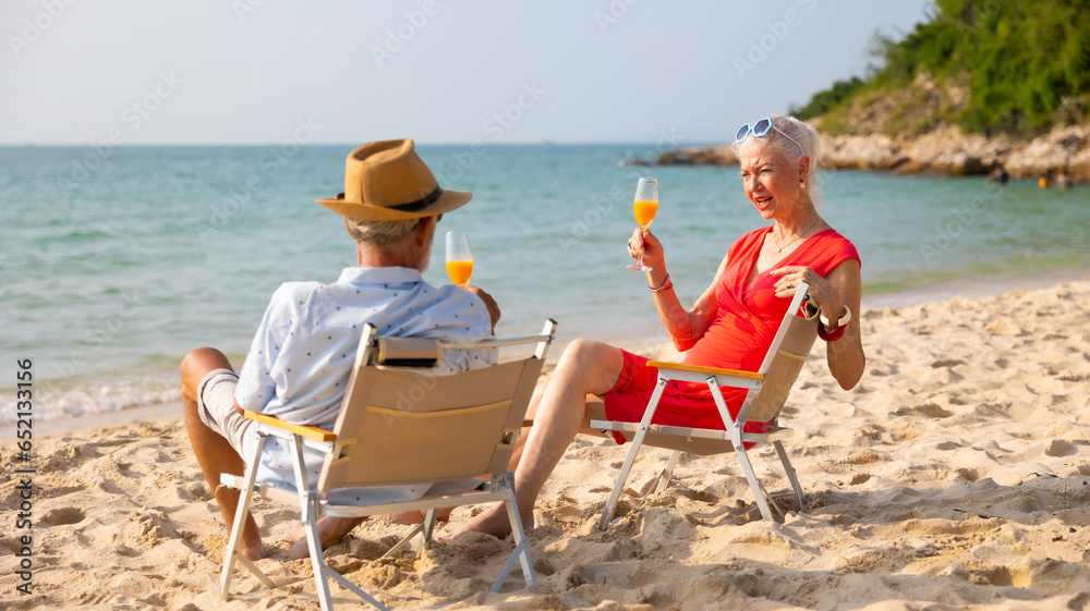 Celebrate Elderly couple man and woman celebration and drinking and looking at the sea sky sitting on chair on beach. Vacation trip summer holiday. Party, Holiday, Summer, Friendship