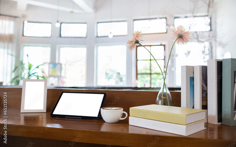 Coffee drink with tablet computer and book, photo fram on wooden counter, interior decoration for a living room or cafe Coffee drink with tablet computer and book, photo fram on wooden counter, interior decoration for a living room or cafe
