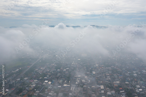 Aerial view of residential neighborhood roofs with fog mist in rainy season. Urban housing development from above. Top view. Real estate in Phuket, southern province city, Thailand.
