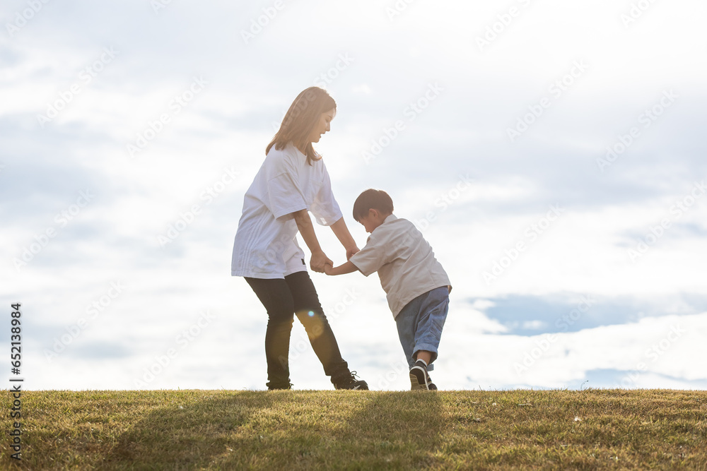 丘の上で手を繋ぐ親子　Parent and child holding hands