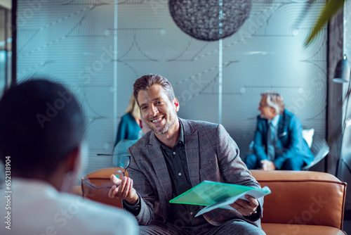 Two coworkers talking in the lobby of a modern business office of a startup company