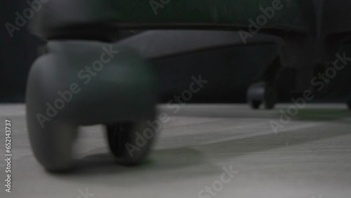 Black plastic wheel of office chair moving on ground floor at office indoor